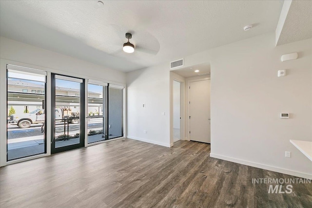 unfurnished room featuring hardwood / wood-style flooring, ceiling fan, and a textured ceiling