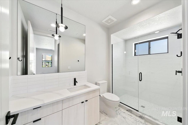 bathroom featuring vanity, toilet, an enclosed shower, and a textured ceiling