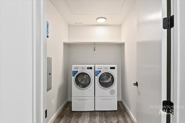 laundry room with independent washer and dryer and dark hardwood / wood-style flooring