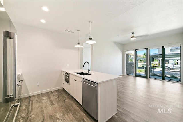 kitchen with dishwasher, sink, dark wood-type flooring, kitchen peninsula, and decorative light fixtures