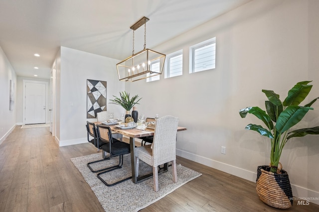 dining area featuring hardwood / wood-style flooring and a chandelier