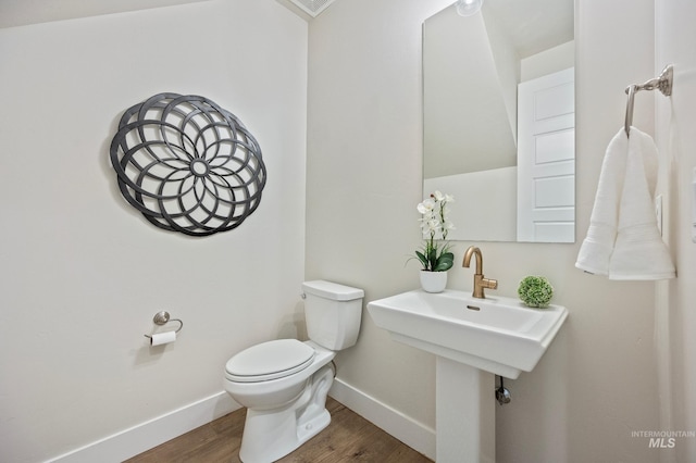 bathroom featuring hardwood / wood-style flooring and toilet