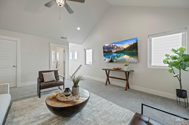 sitting room with vaulted ceiling, light colored carpet, and ceiling fan