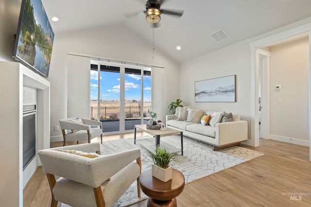 living room featuring lofted ceiling, ceiling fan, and light wood-type flooring