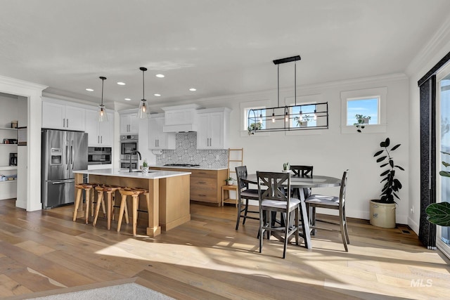 20138 Carbondale Ave, Caldwell, ID 83605 - kitchen featuring stainless steel appliances, light countertops, ornamental molding, a sink, and a kitchen breakfast bar
