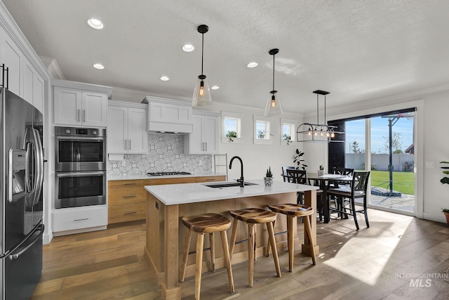 20138 Carbondale Ave, Caldwell, ID 83605 - kitchen featuring black fridge with ice dispenser, crown molding, stainless steel double oven, gas stovetop, and a sink