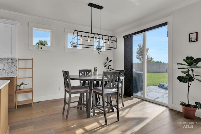 20138 Carbondale Ave, Caldwell, ID 83605 - dining room featuring light wood-type flooring, an inviting chandelier, plenty of natural light, and crown molding
