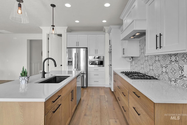 20138 Carbondale Ave, Caldwell, ID 83605 - kitchen featuring light wood finished floors, tasteful backsplash, appliances with stainless steel finishes, a sink, and premium range hood