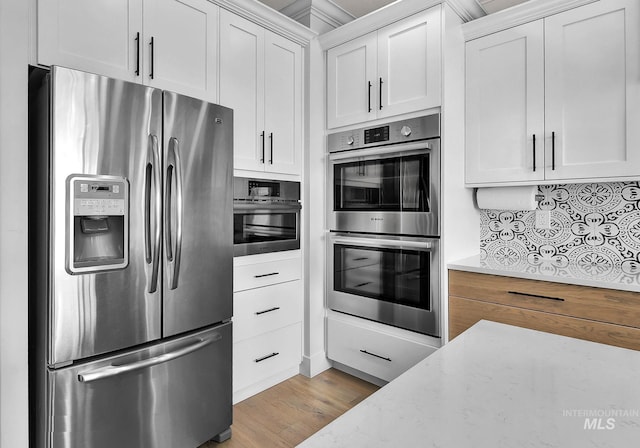 20138 Carbondale Ave, Caldwell, ID 83605 - kitchen featuring appliances with stainless steel finishes, white cabinets, light stone counters, and wood finished floors