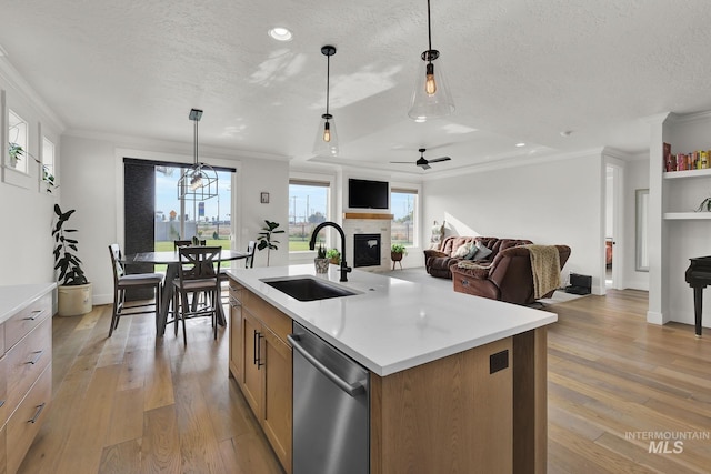 20138 Carbondale Ave, Caldwell, ID 83605 - kitchen featuring light wood finished floors, ornamental molding, a glass covered fireplace, a sink, and dishwasher