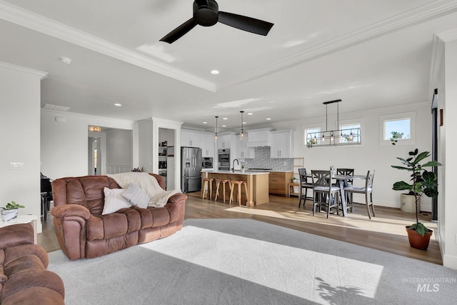 20138 Carbondale Ave, Caldwell, ID 83605 - living area with light wood finished floors, ceiling fan with notable chandelier, ornamental molding, and recessed lighting