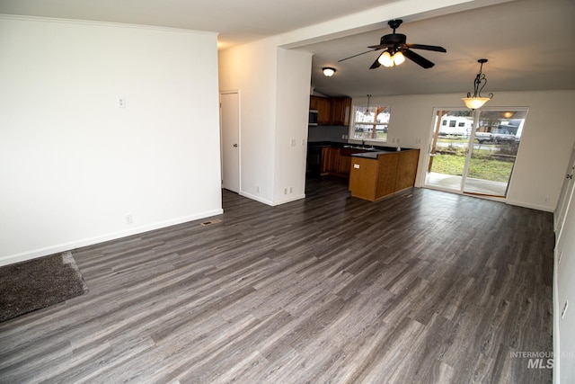 unfurnished living room featuring dark hardwood / wood-style floors and ceiling fan