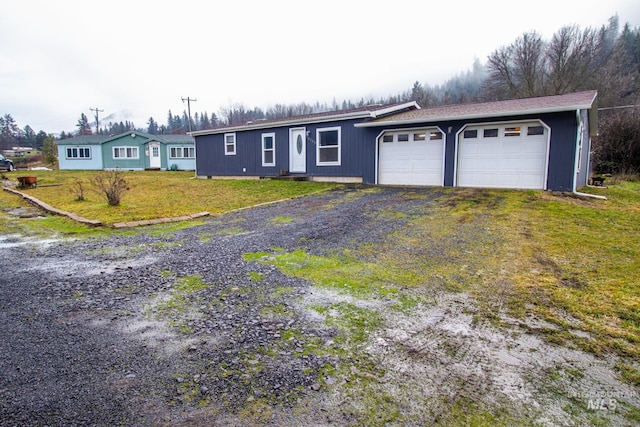 ranch-style house with a garage and a front lawn