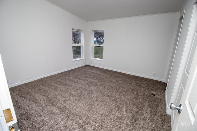 unfurnished room featuring dark carpet, crown molding, and lofted ceiling