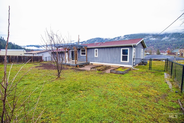 rear view of property featuring a wooden deck and a yard