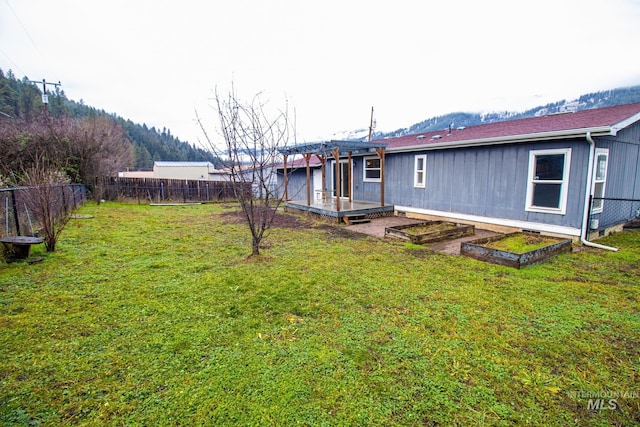 rear view of property with a deck and a lawn