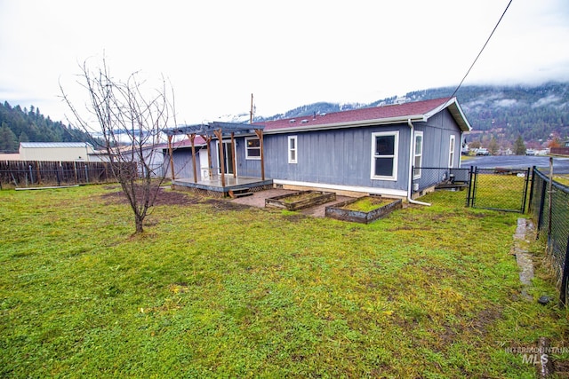 back of house with a lawn and a deck