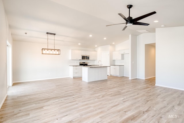 1722 SW Besra Dr, Mountain Home, ID 83647 - unfurnished living room with a sink, recessed lighting, vaulted ceiling, light wood finished floors, and baseboards