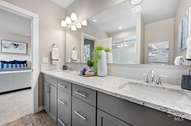 bathroom featuring vanity, backsplash, and wood-type flooring