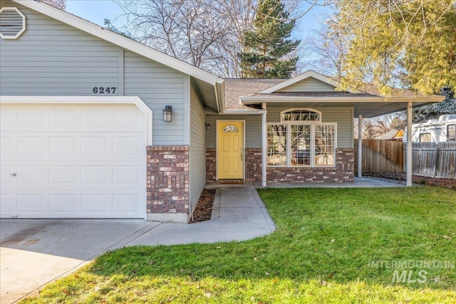 entrance to property featuring a lawn and a garage