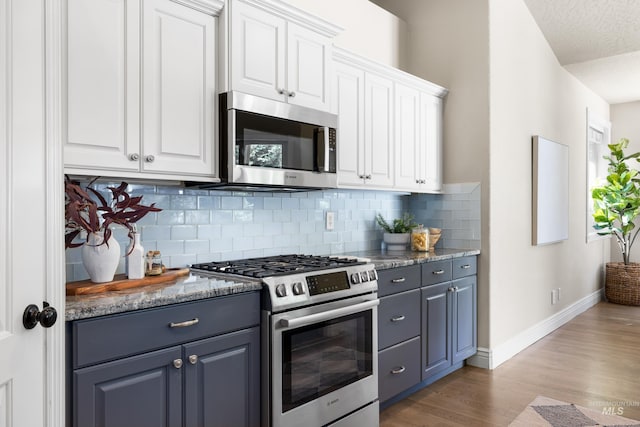 12258 Whitechapel Way, Nampa, ID 83686 - kitchen with appliances with stainless steel finishes, baseboards, tasteful backsplash, light wood finished floors, and white cabinetry