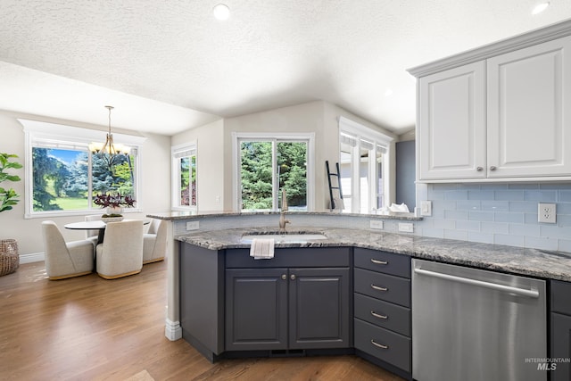 12258 Whitechapel Way, Nampa, ID 83686 - kitchen featuring dishwasher, a sink, wood finished floors, backsplash, and white cabinets