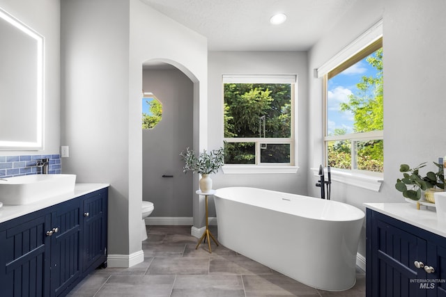 12258 Whitechapel Way, Nampa, ID 83686 - bathroom featuring vanity, toilet, plenty of natural light, a freestanding tub, and recessed lighting