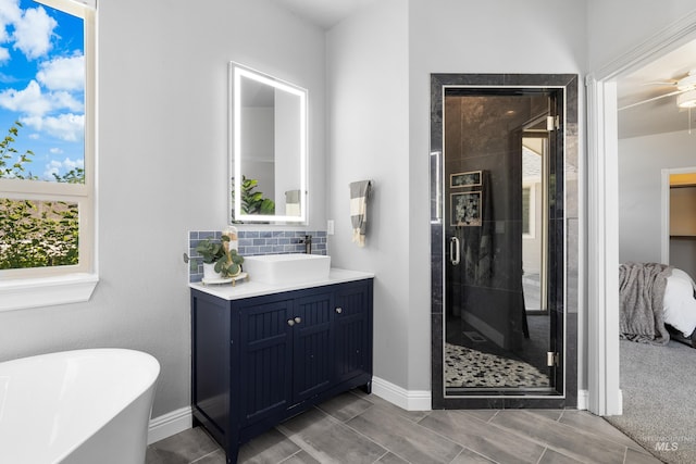12258 Whitechapel Way, Nampa, ID 83686 - full bathroom with a shower stall, a soaking tub, backsplash, vanity, and baseboards