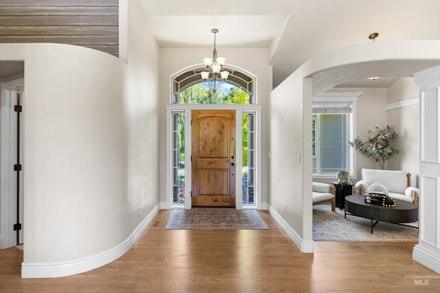 12258 Whitechapel Way, Nampa, ID 83686 - foyer entrance with healthy amount of natural light, a chandelier, arched walkways, and wood finished floors