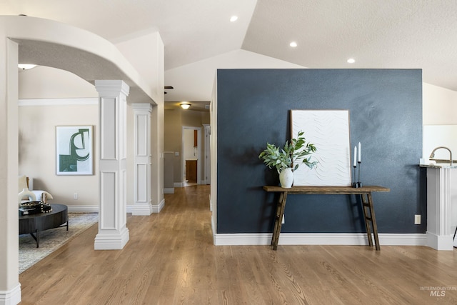 12258 Whitechapel Way, Nampa, ID 83686 - corridor featuring ornate columns, lofted ceiling, wood finished floors, arched walkways, and baseboards
