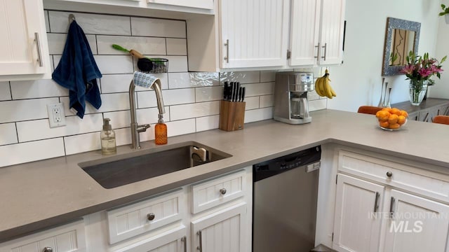 2927 N 32nd St, Boise, ID 83703 - kitchen with stainless steel dishwasher, a sink, white cabinets, and backsplash