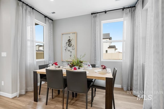 dining area with baseboards, plenty of natural light, and light wood-style flooring