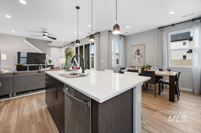 kitchen featuring visible vents, a sink, light countertops, dishwasher, and open floor plan