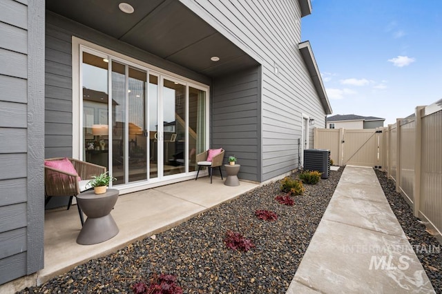 exterior space featuring fence, central AC, and a gate