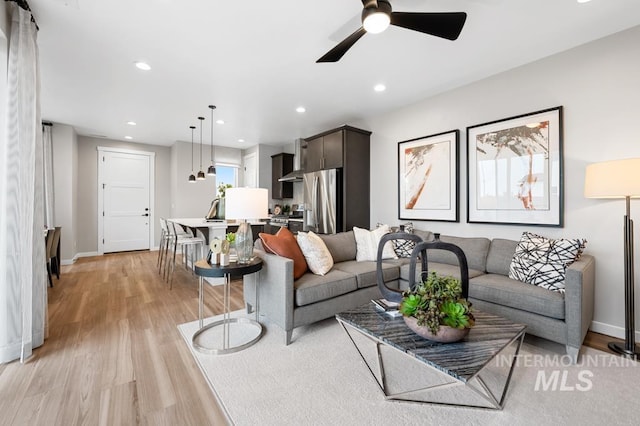 living area featuring recessed lighting, light wood-type flooring, baseboards, and a ceiling fan