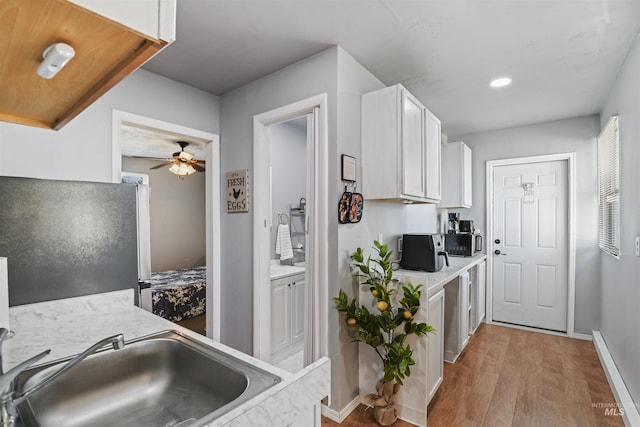 11457 S Cloverdale, Kuna, ID 83634 - kitchen with freestanding refrigerator, ceiling fan, white cabinetry, wood finished floors, and baseboards
