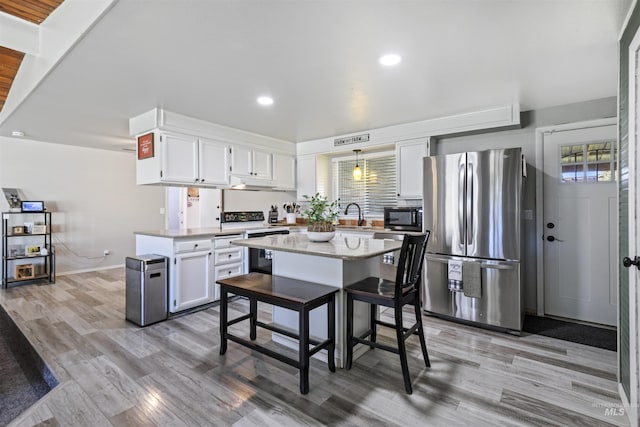 11457 S Cloverdale, Kuna, ID 83634 - kitchen with freestanding refrigerator, a peninsula, light wood-style floors, white cabinetry, and electric range
