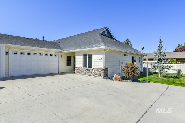 325 S Whisperwood Way, Boise, ID 83709 - view of front facade with fence, stone siding, a shingled roof, an attached garage, and driveway