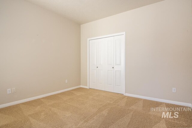 325 S Whisperwood Way, Boise, ID 83709 - unfurnished bedroom featuring baseboards, light carpet, and a closet