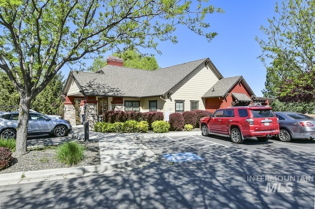 325 S Whisperwood Way, Boise, ID 83709 - view of front of house with uncovered parking, roof with shingles, and a chimney