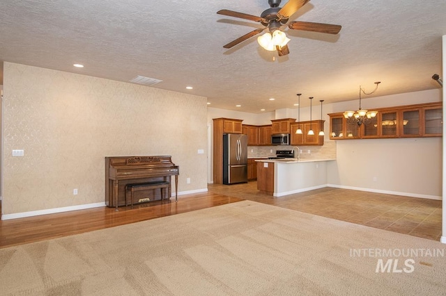 325 S Whisperwood Way, Boise, ID 83709 - kitchen featuring brown cabinets, light carpet, stainless steel appliances, open floor plan, and visible vents