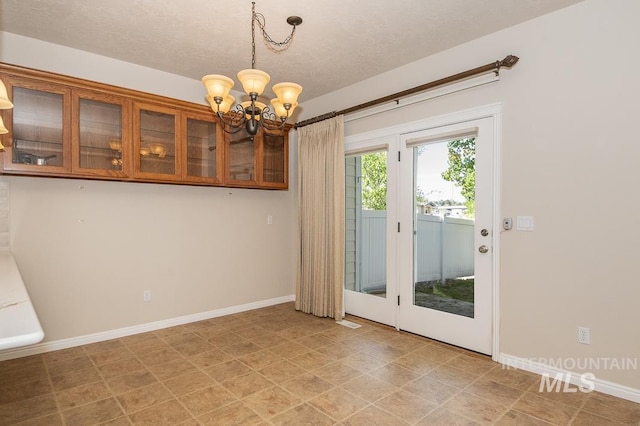 325 S Whisperwood Way, Boise, ID 83709 - unfurnished dining area with baseboards, a textured ceiling, and a notable chandelier