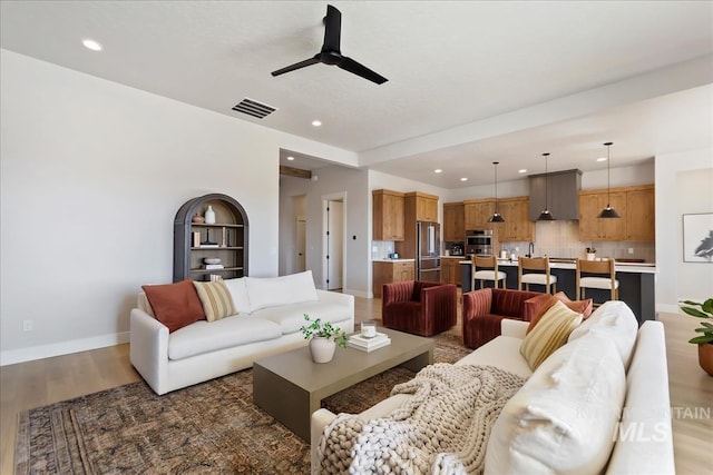 living room with dark wood-type flooring and ceiling fan