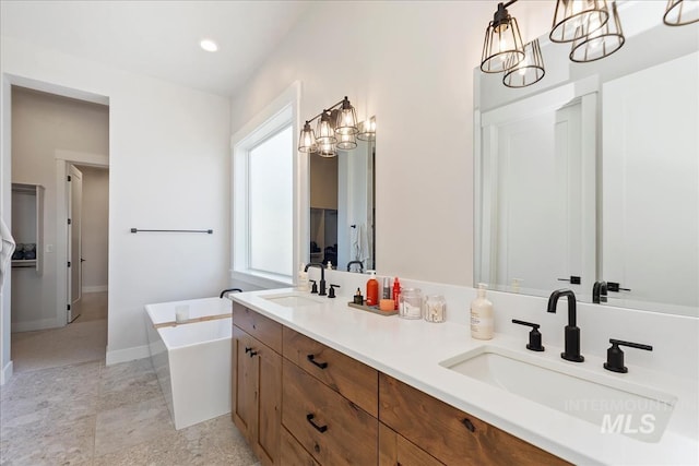 bathroom featuring vanity, a bath, and a notable chandelier