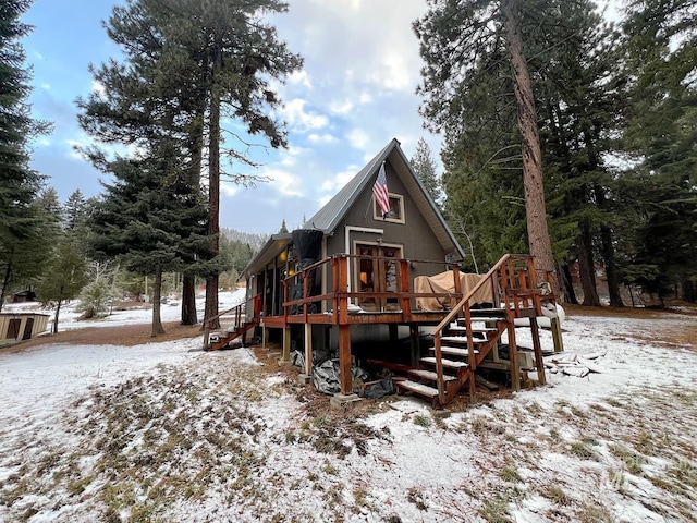 snow covered rear of property featuring a wooden deck