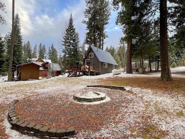 yard covered in snow with a storage shed and a deck