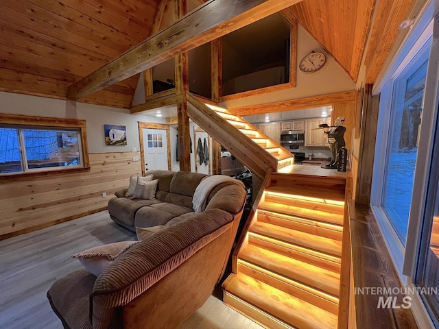 living room featuring hardwood / wood-style flooring, lofted ceiling with beams, wood walls, and wooden ceiling