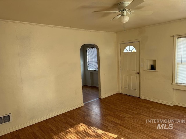foyer entrance featuring plenty of natural light, visible vents, arched walkways, and ceiling fan