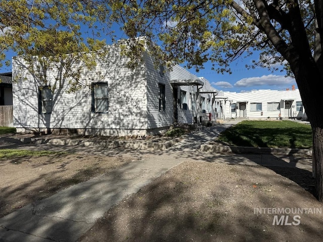 view of side of home featuring a pergola and a yard