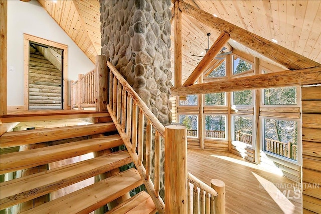 stairway featuring beam ceiling, high vaulted ceiling, wooden ceiling, and hardwood / wood-style flooring